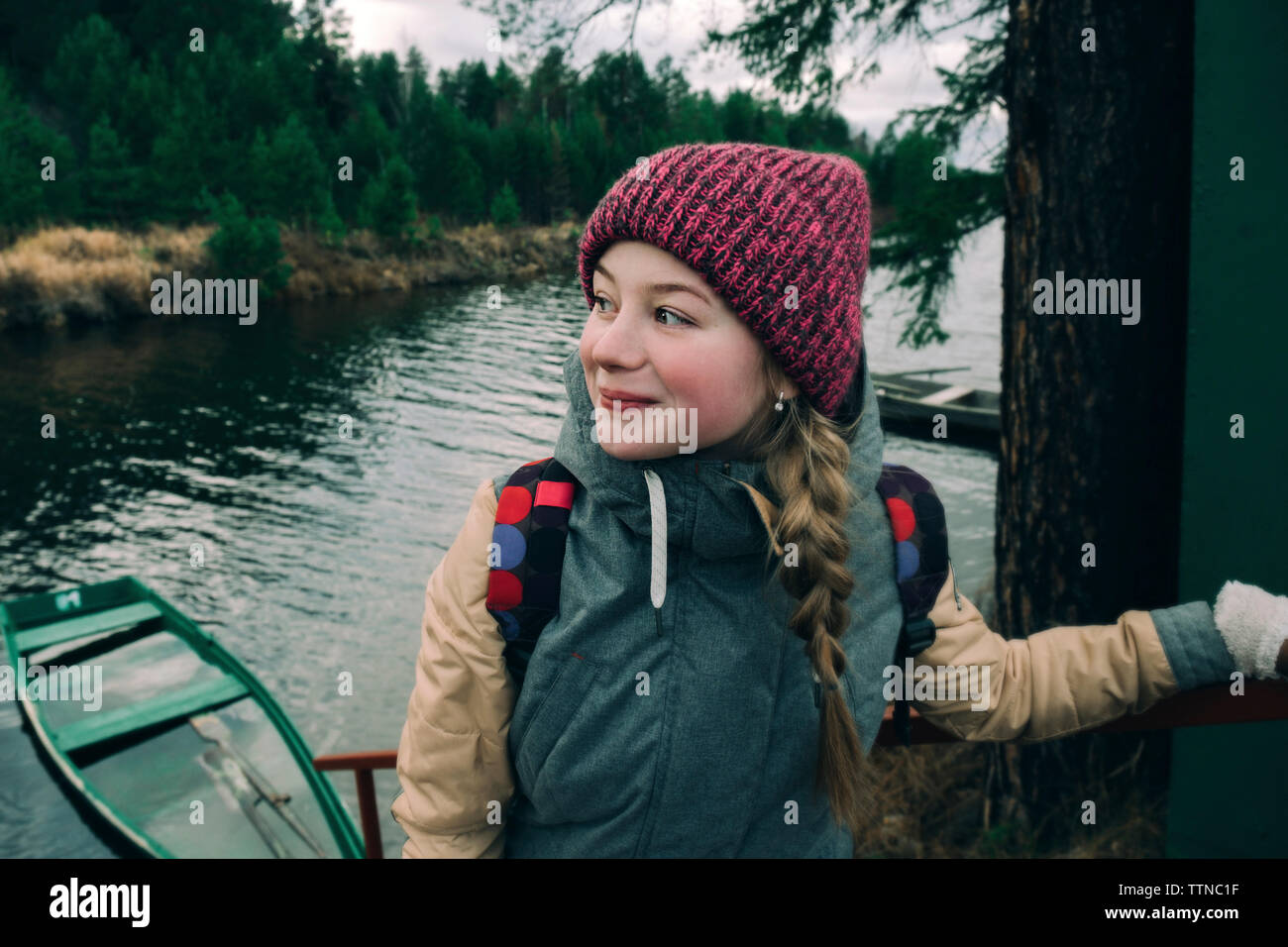 Beautiful girl in warm clothes by the river Stock Photo