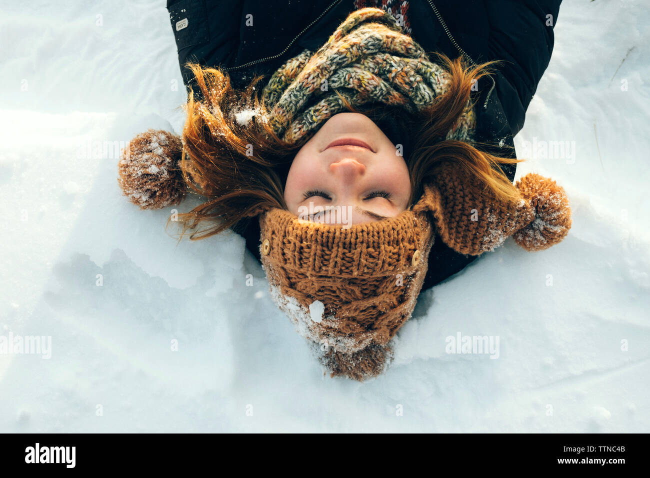 Woman lying in the snow Stock Photo