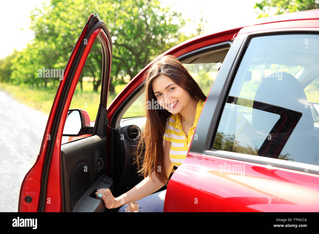 Young beautiful woman in red car Stock Photo - Alamy