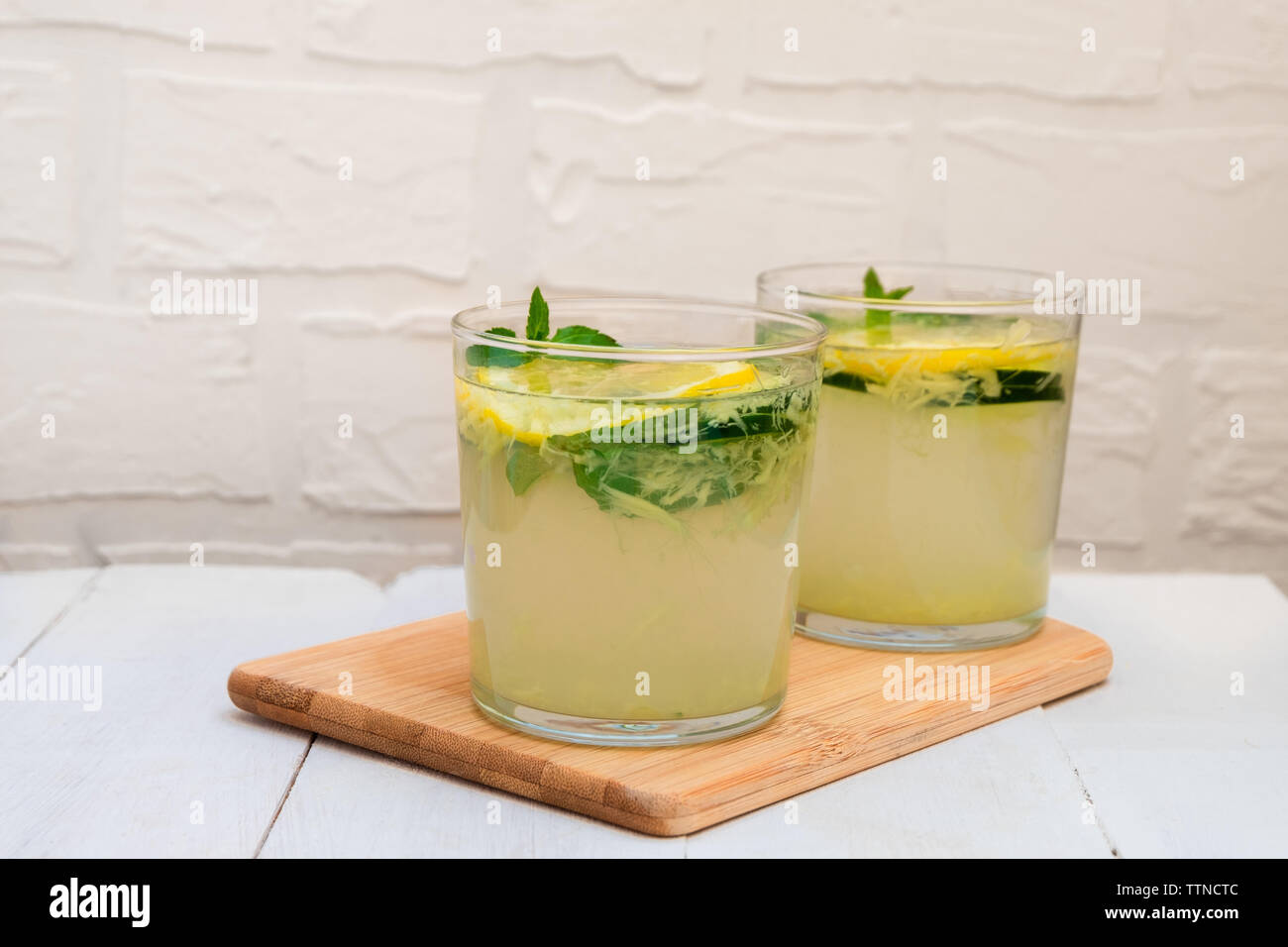 Two glasses of Sassy Water on wooden board on white background with copy space Stock Photo