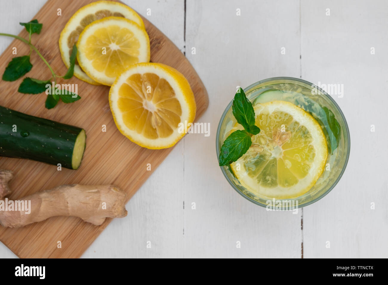 Glass of detox Sassy Water with lemon, cucumber, ginger, mint on white wooden table Stock Photo