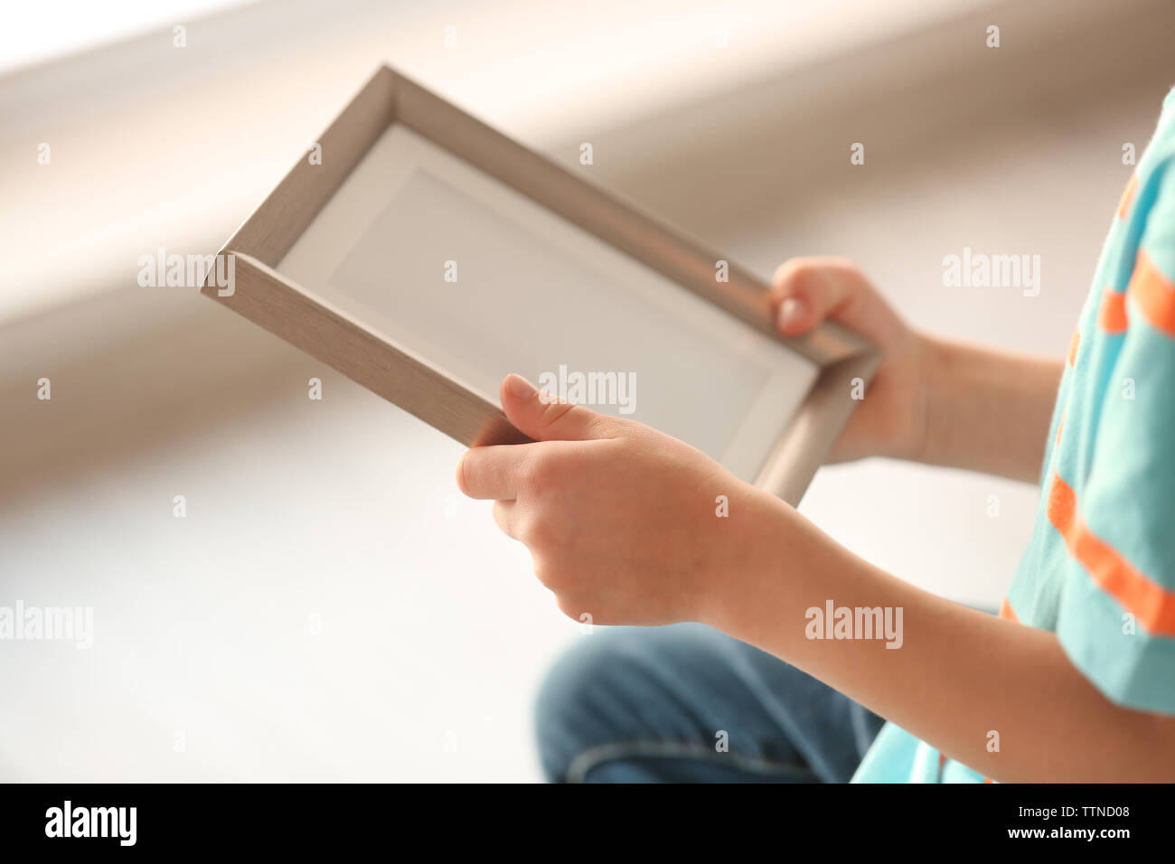 Child's hands holding photo frame on light background Stock Photo - Alamy