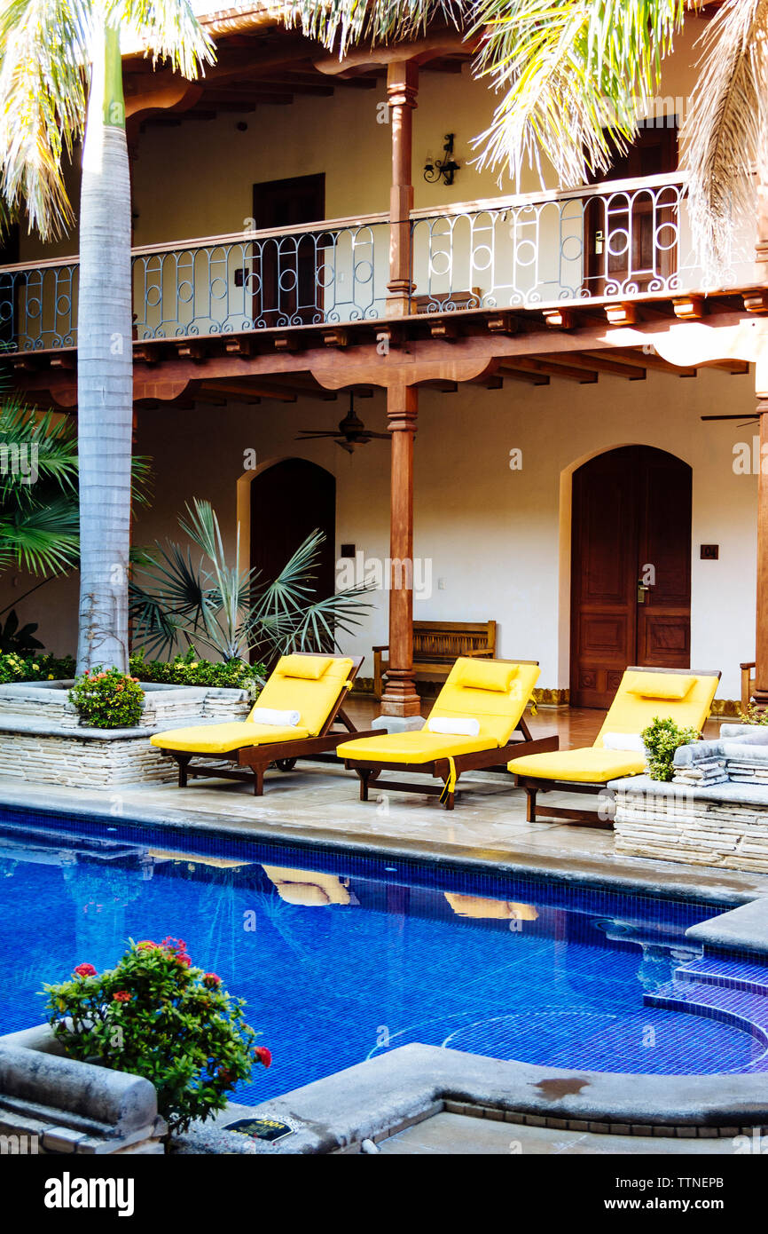 Lounge chairs by swimming pool at luxury hotel Stock Photo