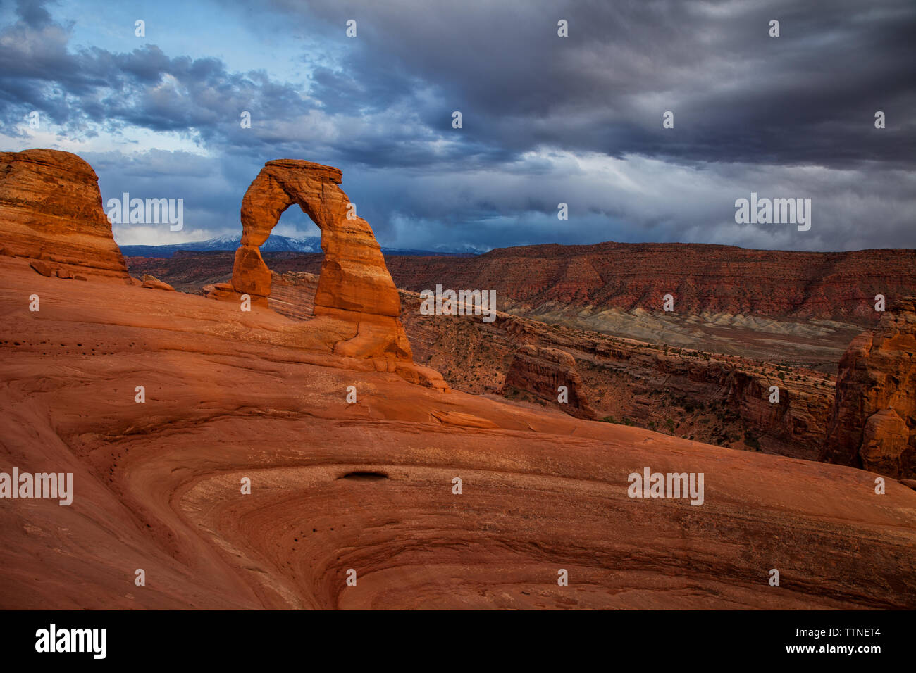 Storm clouds linger in the sky above Delicate Arch in Arches 