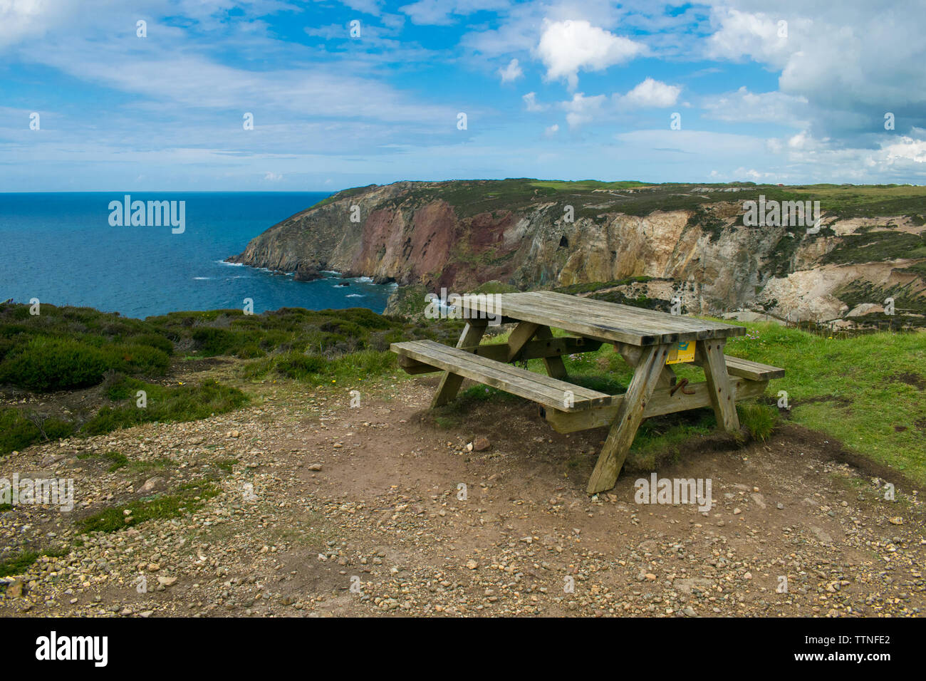 Empty picnic bench overlooking the Cornish coast at Perranporth,Cornwall,United Kingdom. Stock Photo