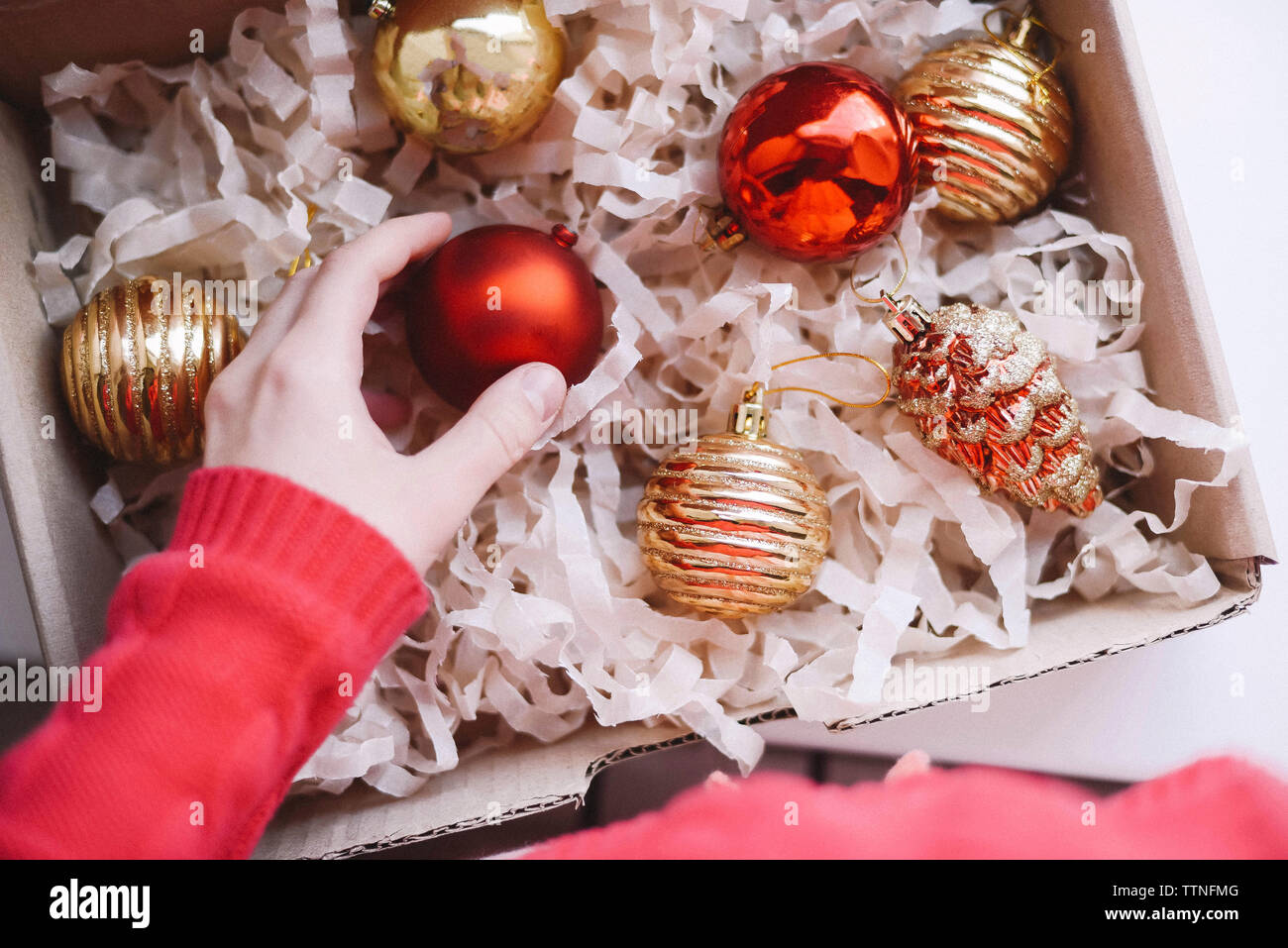 Cropped hand of woman taking bauble from box Stock Photo