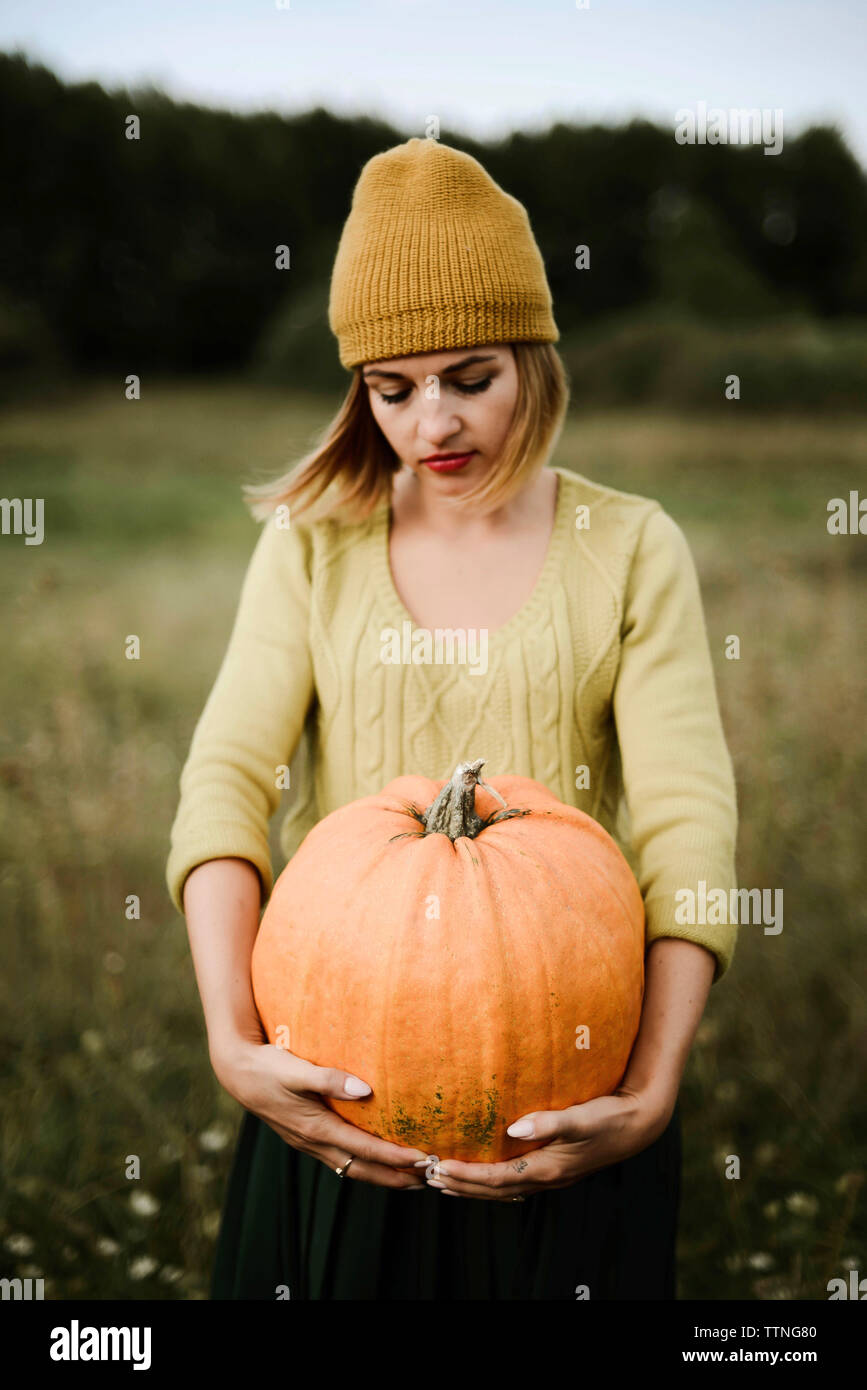 Portrait of woman carrying pumpkin while standing outdoor in autumn Stock Photo