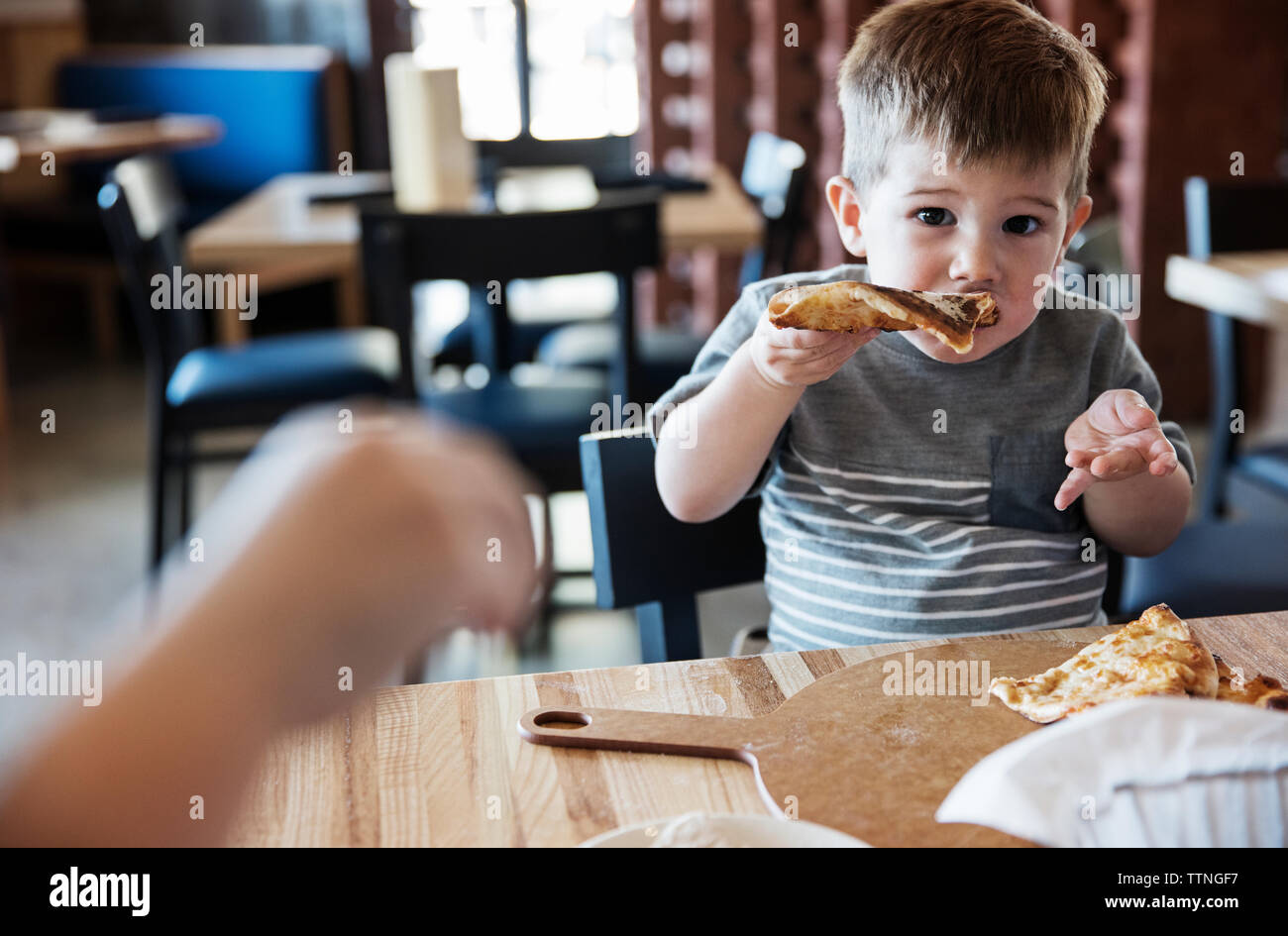 Portrait of cute boy eating pizza at restaurant Stock Photo