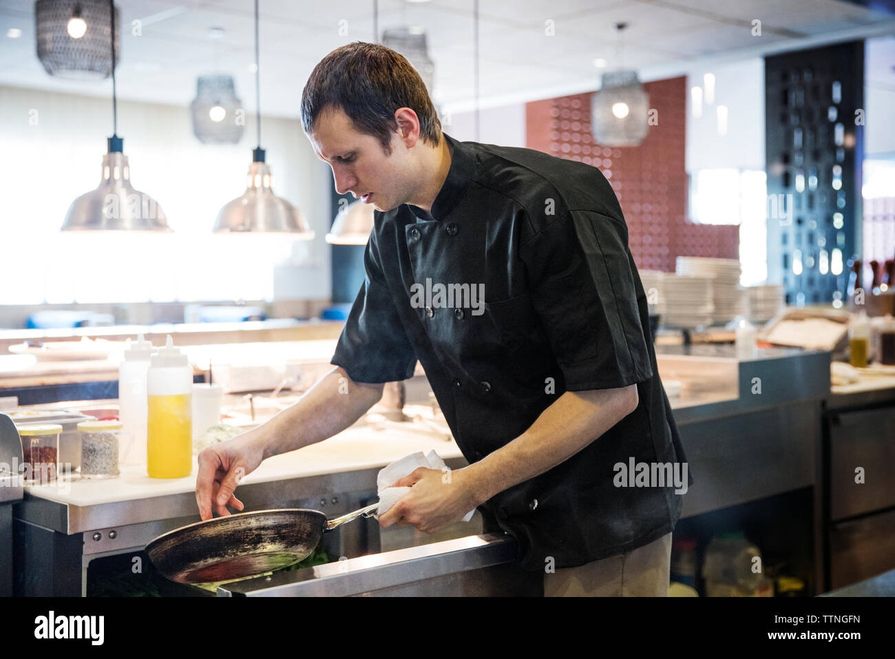 Male chef preparing food in commercial kitchen Stock Photo