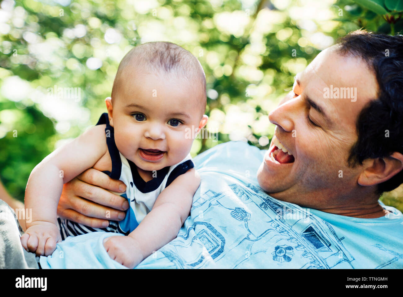 Close-up of father playing with baby boy in backyard Stock Photo