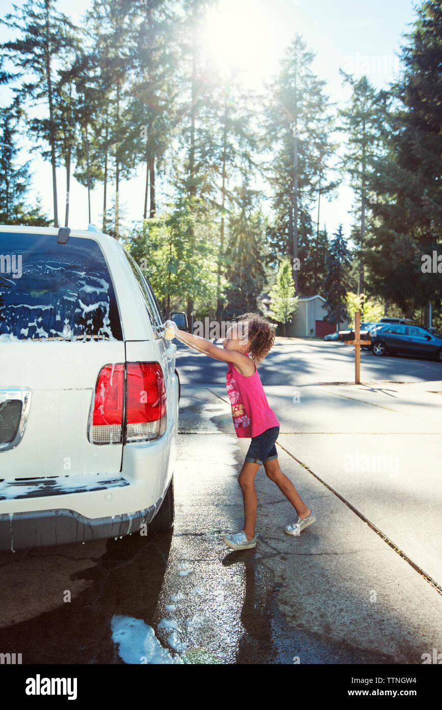 Side view of girl washing car in driveway Stock Photo Alamy