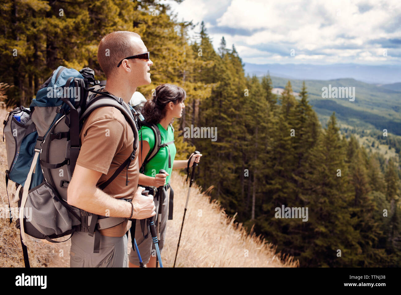 Male and female hiker standing on mountain Stock Photo - Alamy