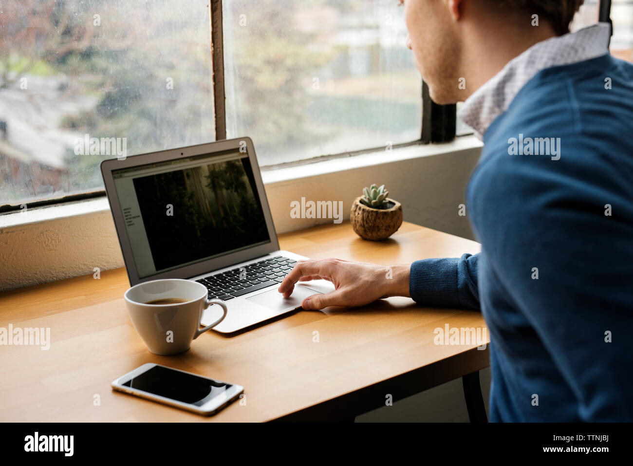 Man using laptop on table in cafe Stock Photo