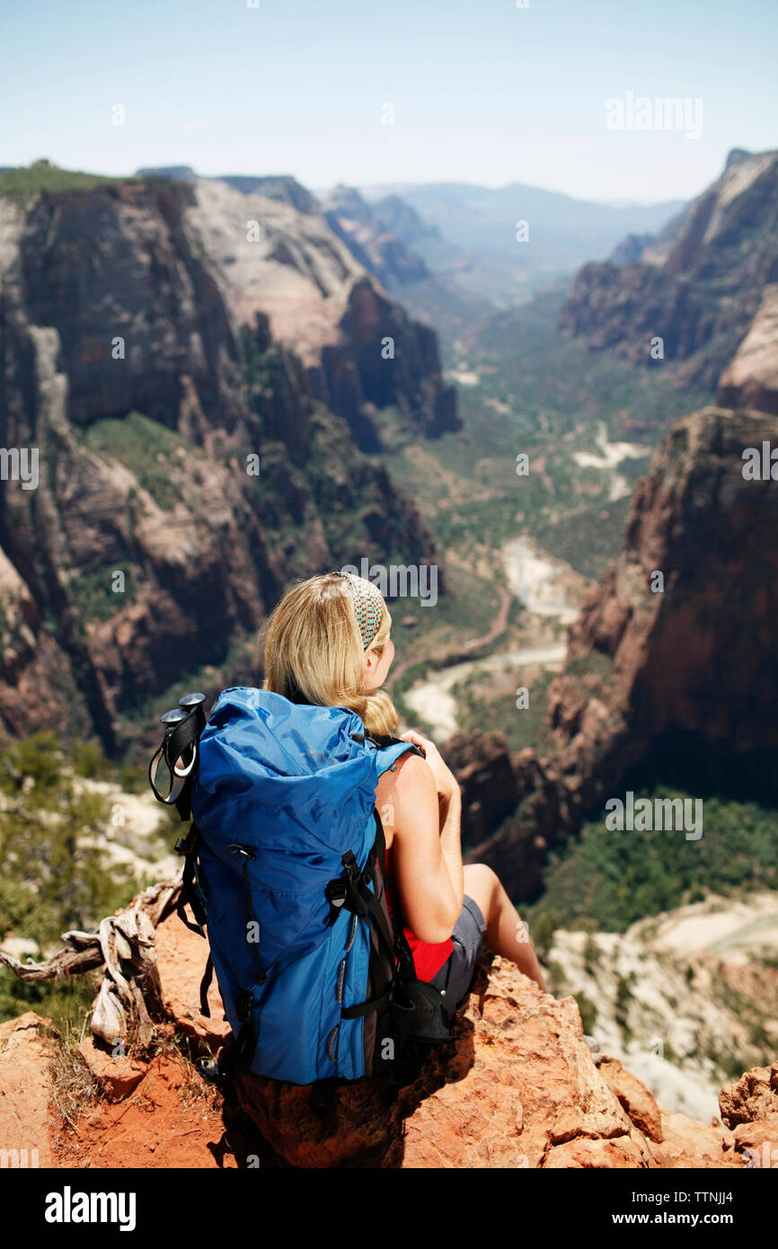Rear view of female hiker sitting on mountain cliff Stock Photo - Alamy