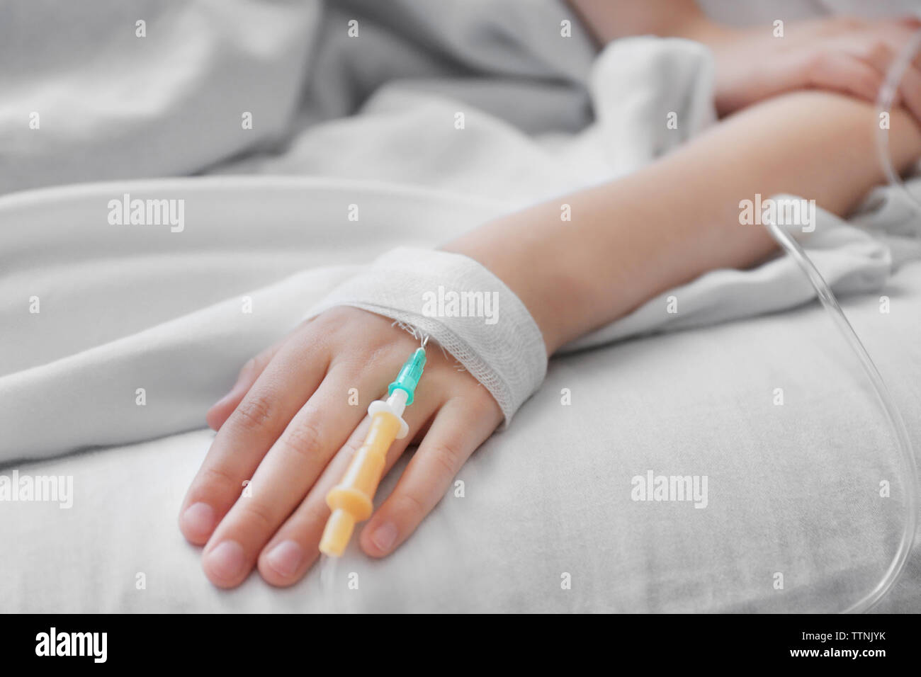 Girl hand with drip infusion on bed Stock Photo - Alamy