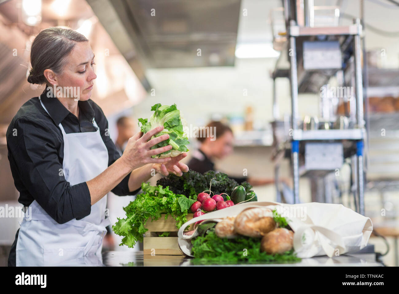 Female chef preparing food in restaurant kitchen Stock Photo