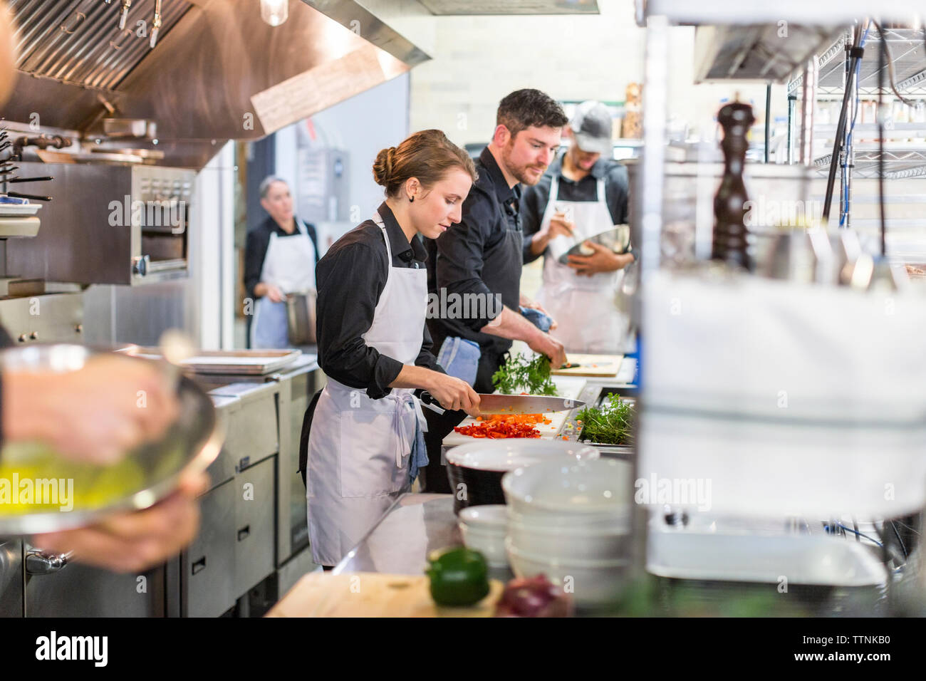 Chefs preparing food in kitchen at restaurant Stock Photo