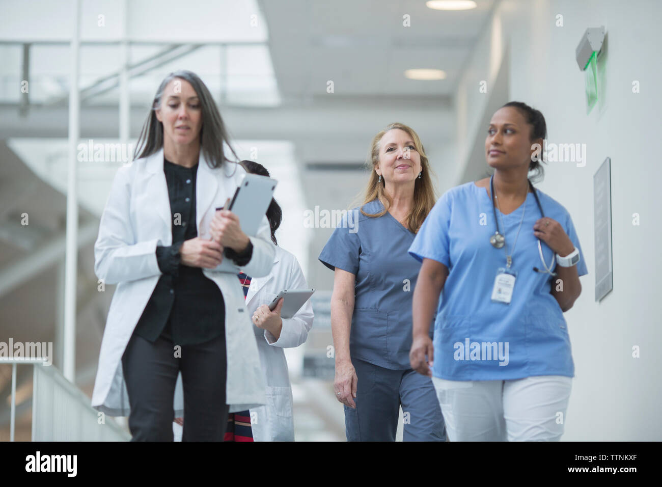 Female doctors walking in hospital corridor Stock Photo