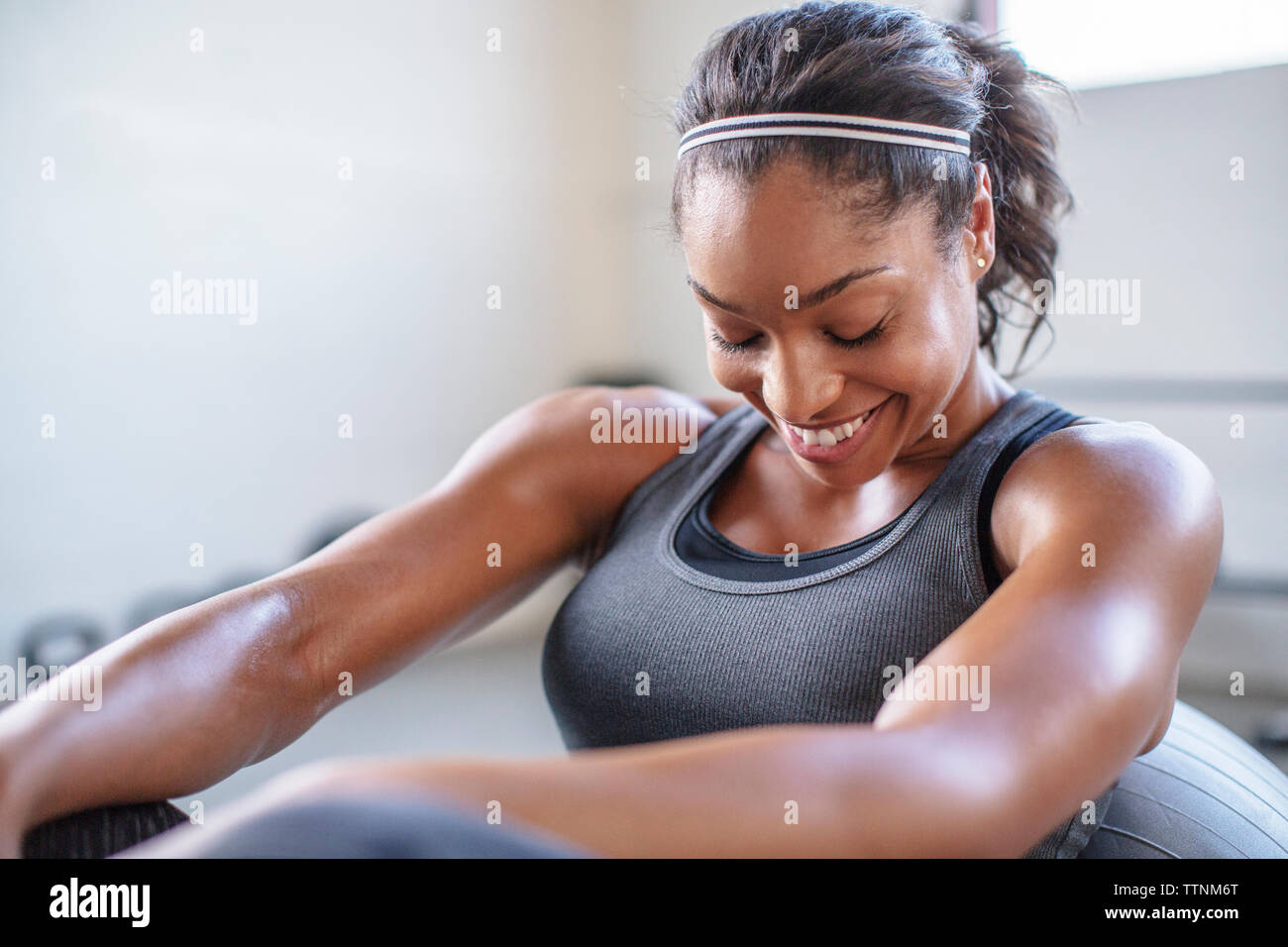 Smiling athlete exercising with medicine ball in gym Stock Photo