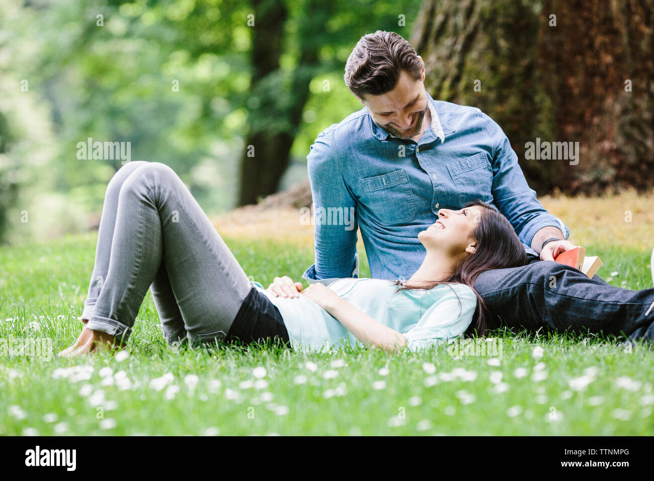 Happy girlfriend lying on boyfriend's lap in park Stock Photo
