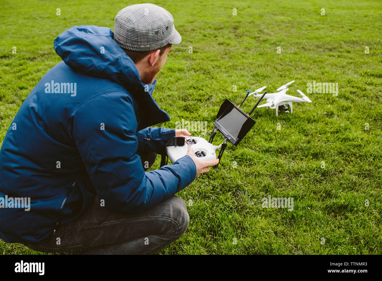 Side view of man flying quadcopter in park Stock Photo