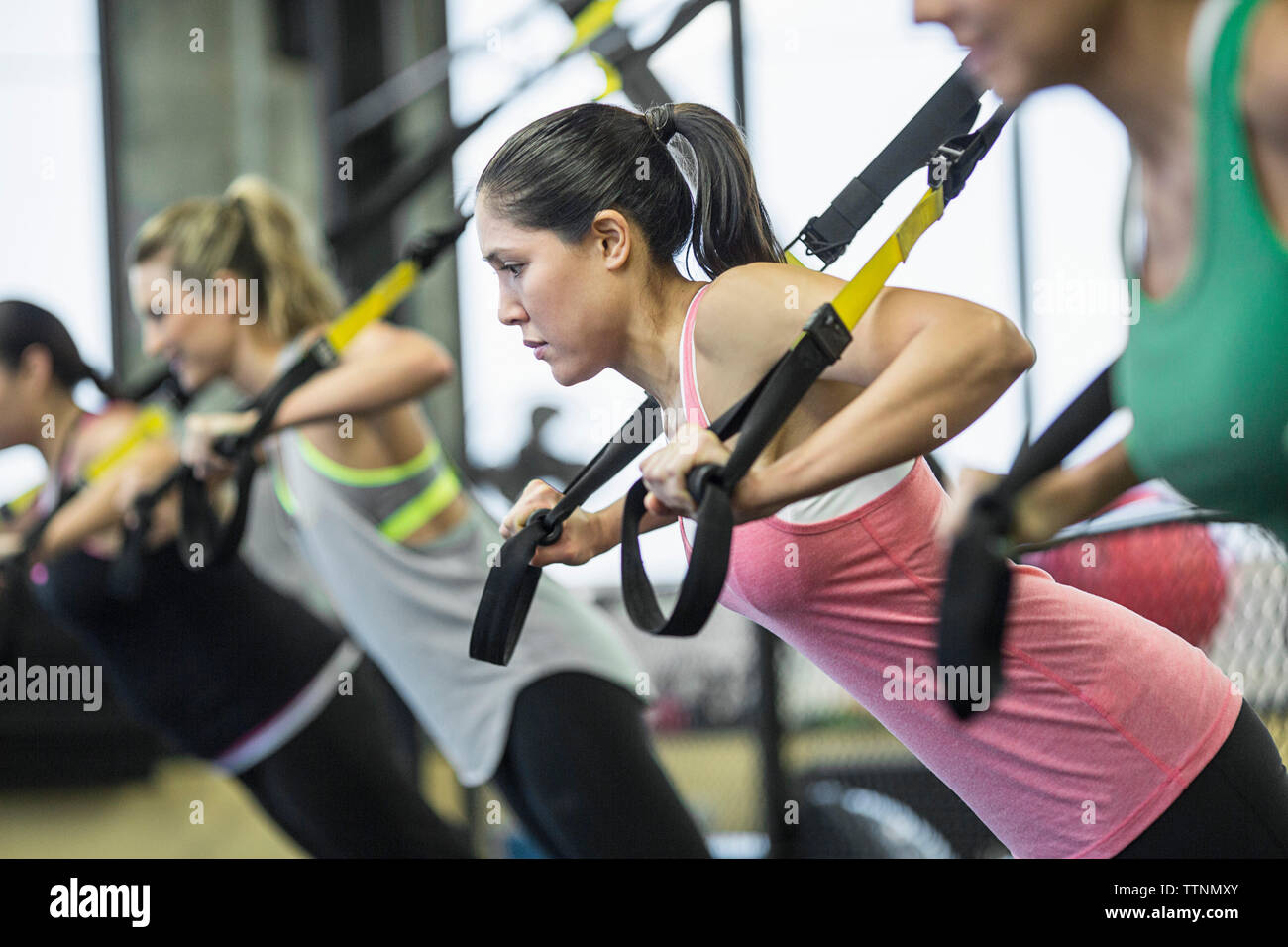 Women pulling resistance bands in gym Stock Photo
