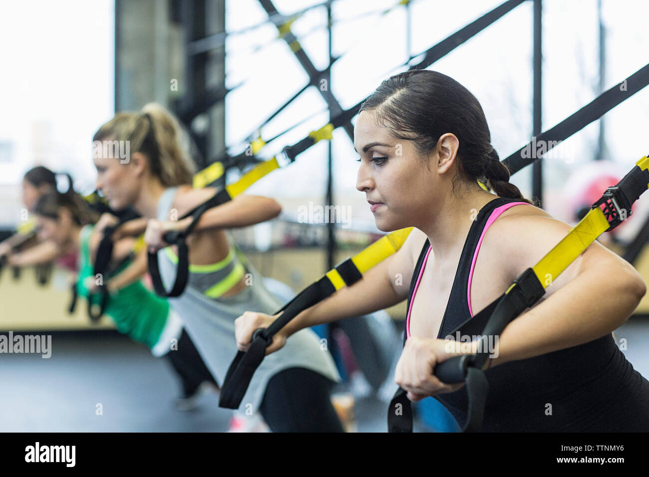 Women exercising with resistance bands in gym Stock Photo