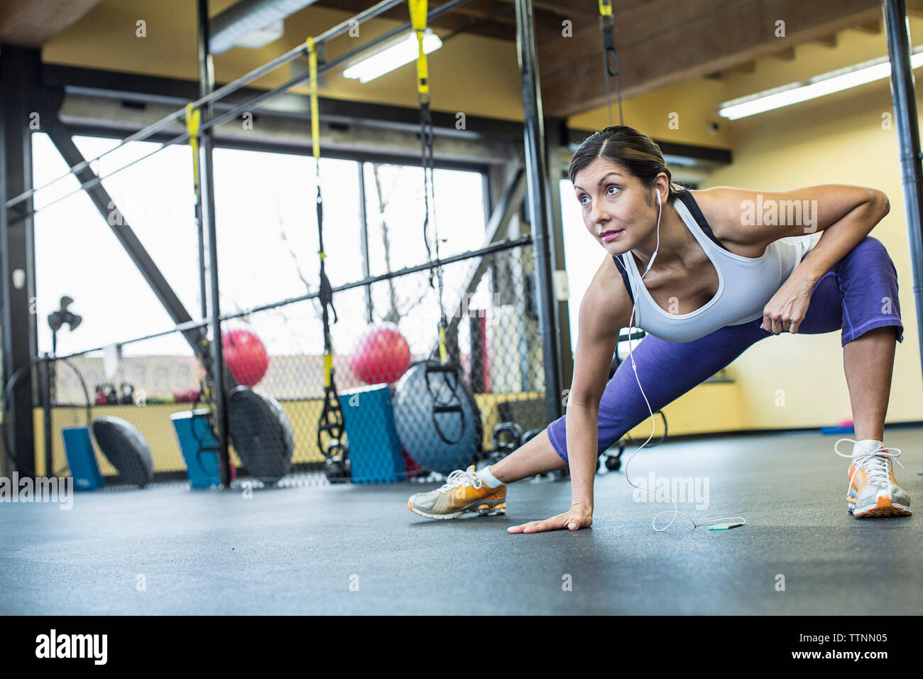 Confident woman listening music while exercising in gym Stock Photo