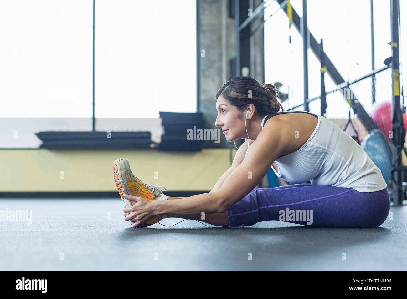 Side view of woman looking away while exercising in gym Stock Photo