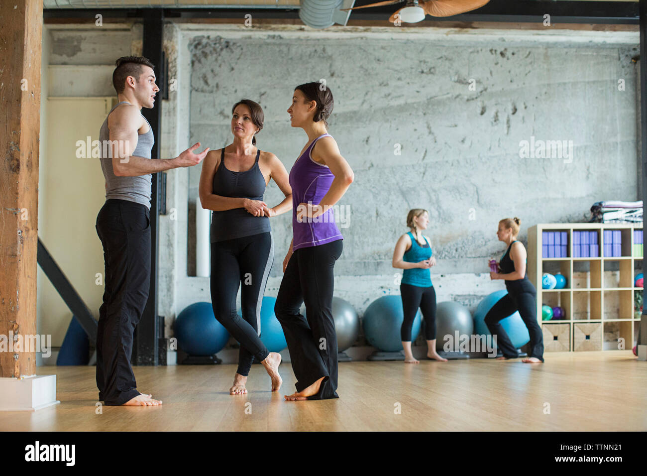 Male instructor guiding women in gym Stock Photo