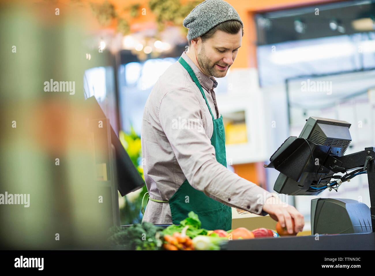 Man working while standing by counter at supermarket Stock Photo