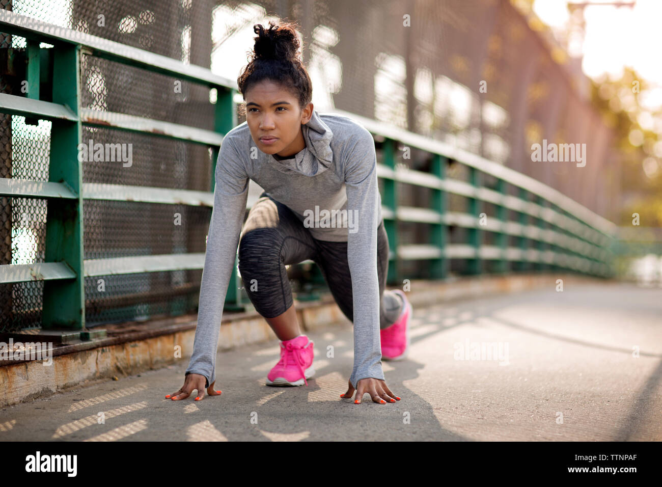 Determined female jogger on footpath Stock Photo
