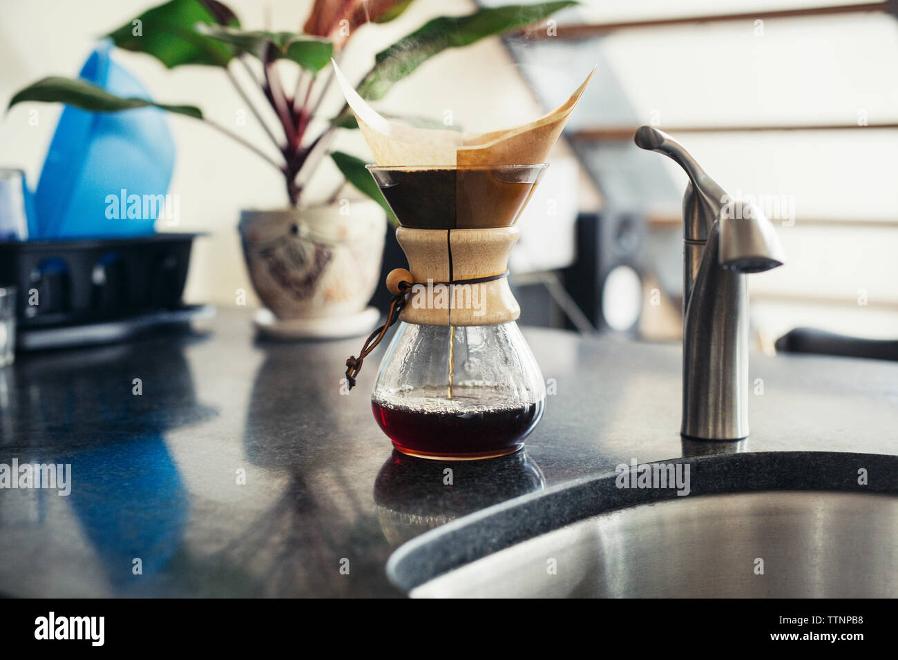 Coffee filter by faucet on kitchen counter Stock Photo