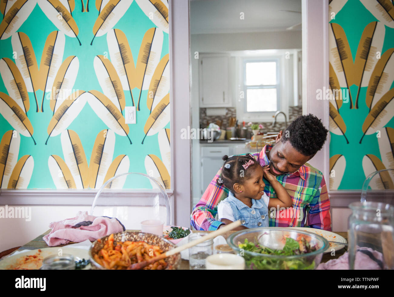 Father talking to daughter at dining table Stock Photo