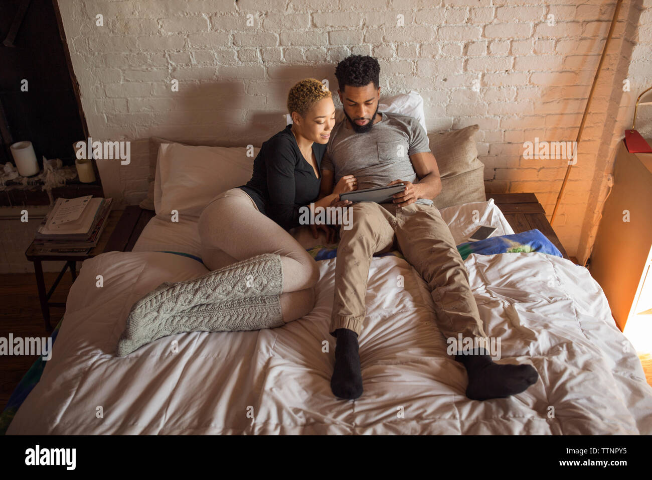 Overhead view of multi-ethnic couple using tablet computer on bed Stock Photo