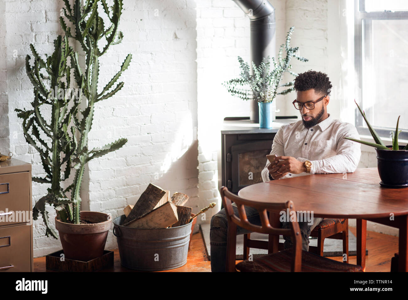 Young man using smart phone at home Stock Photo