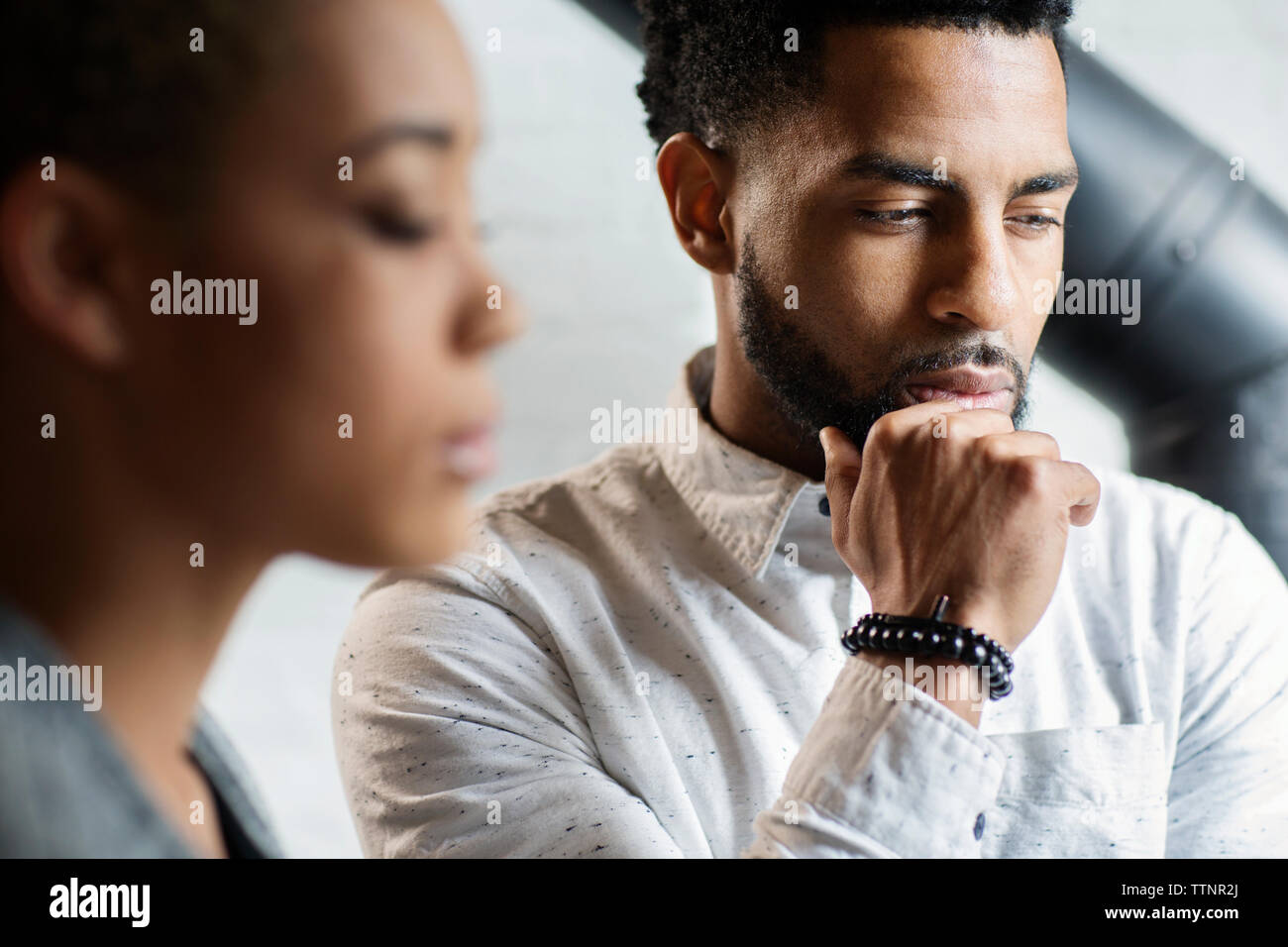 Thoughtful young man by woman at home Stock Photo