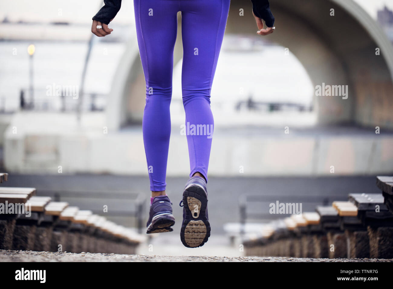 Low section of sporty woman jogging at stadium Stock Photo