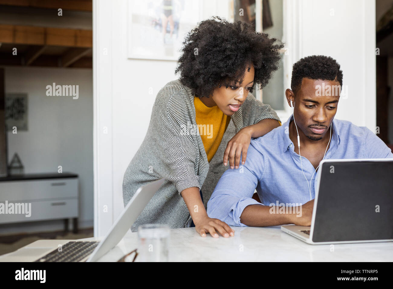 Woman looking while boyfriend using laptop computer at table Stock Photo
