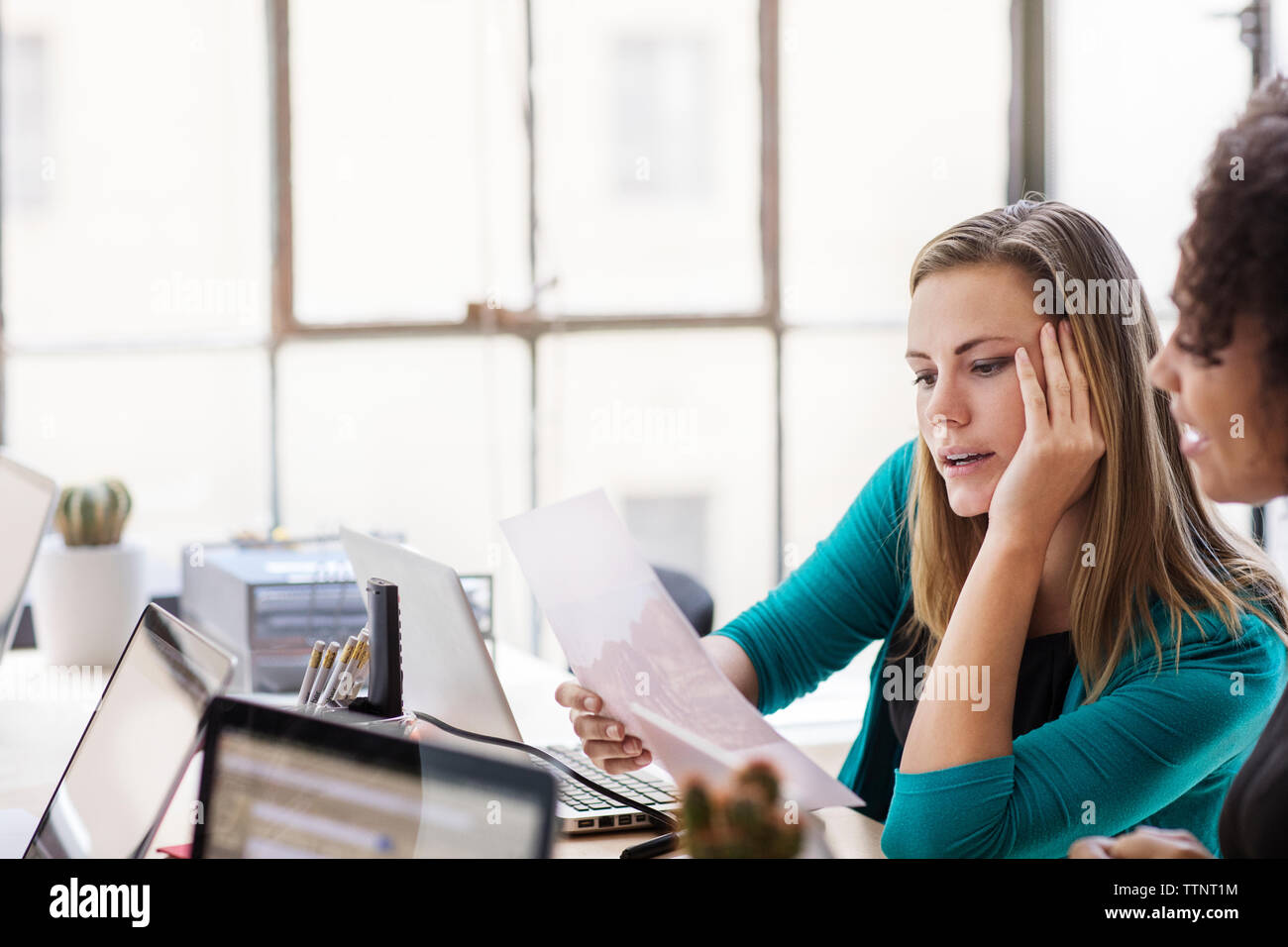 businesswomen discussing over documents at office Stock Photo