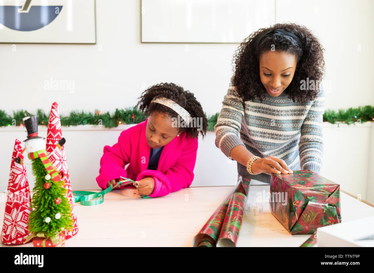 Mother and daughter wrapping christmas presents at home Stock Photo