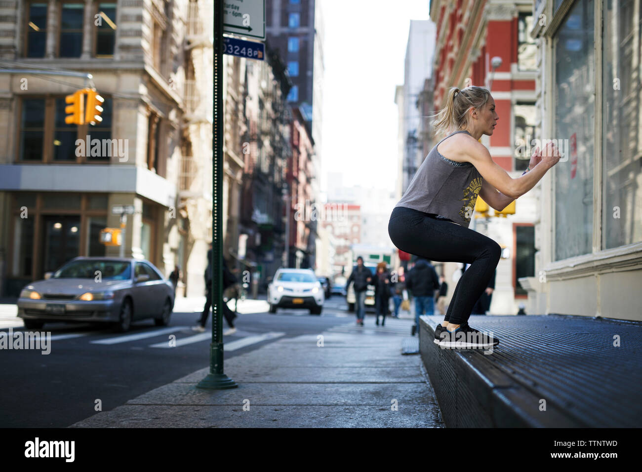 Athlete exercising at sidewalk in city Stock Photo
