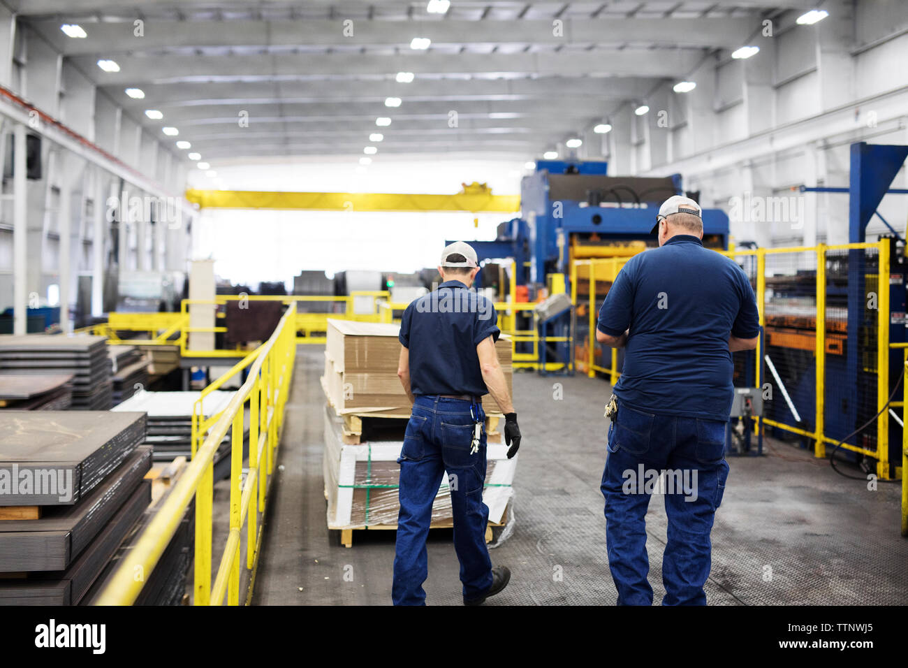 Rear view of manual workers working in Steel industry mill Stock Photo