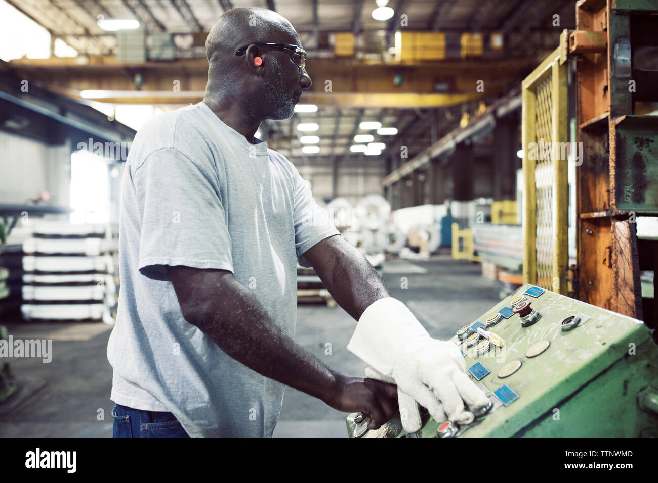 Manual worker using control machine while working in steel industry Stock Photo
