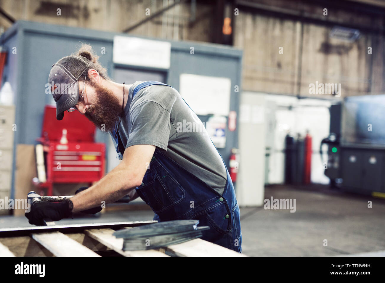Manual worker using hammer and chisel in steel factory Stock Photo - Alamy