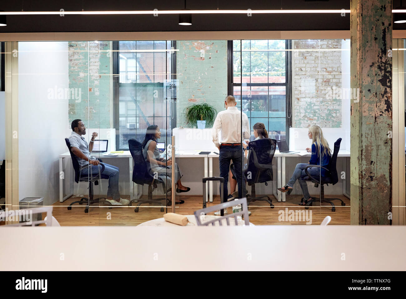 Business people working in office seen through glass wall Stock Photo