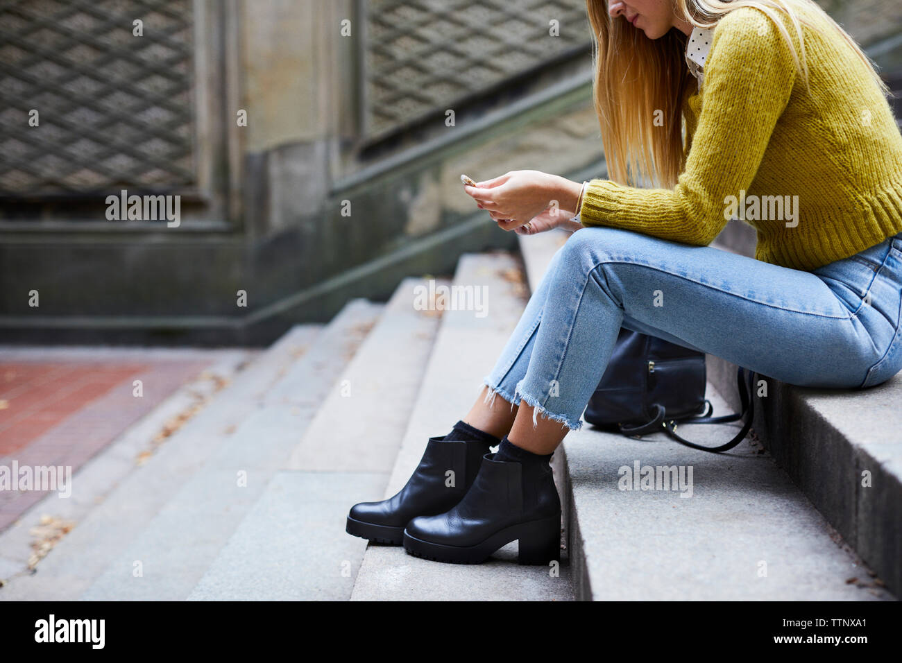 Woman sitting on steps side hi-res stock photography and images - Alamy