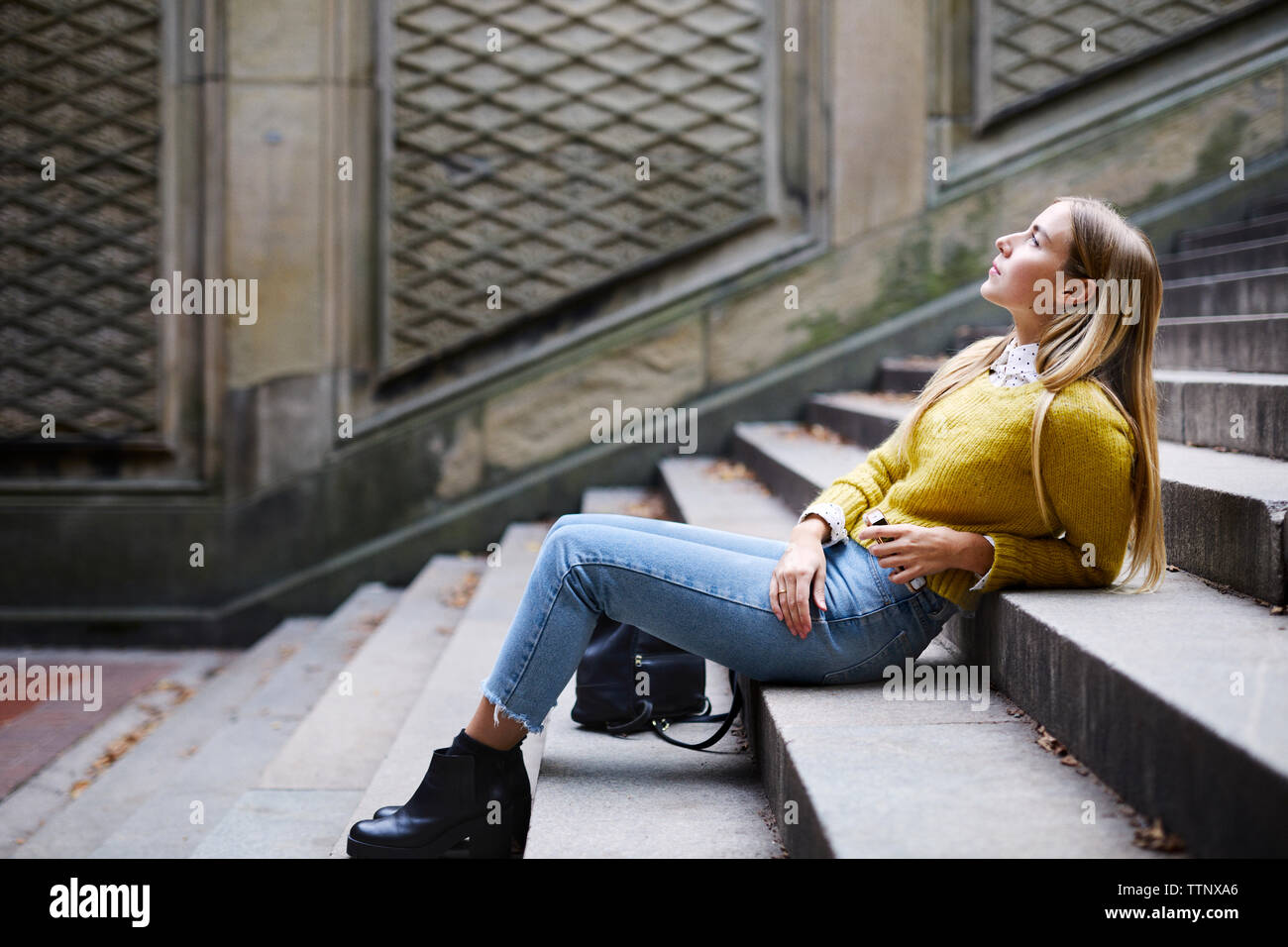 Woman sitting on steps side hi-res stock photography and images - Alamy