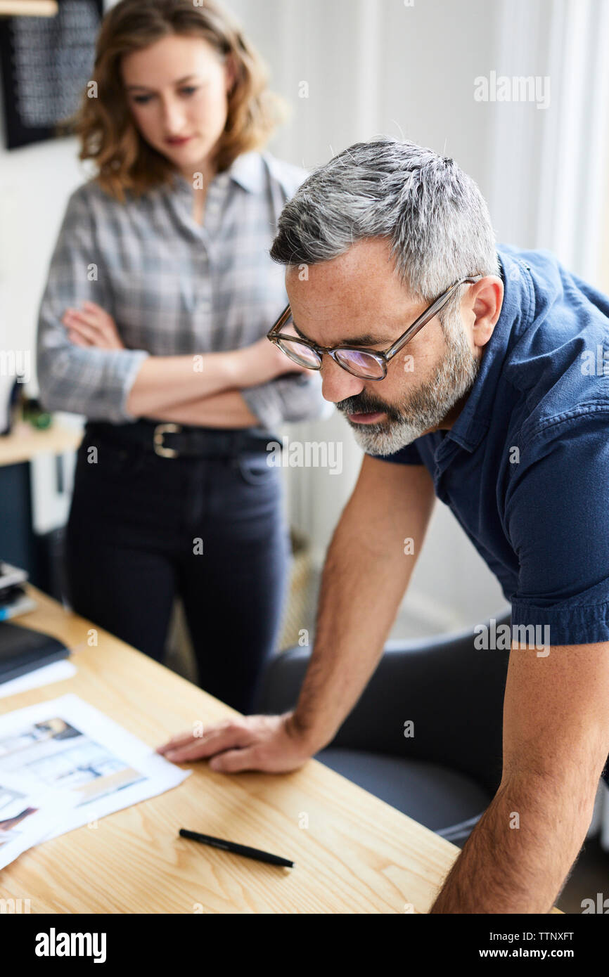 Businessman discussing with female colleague at desk in creative office Stock Photo