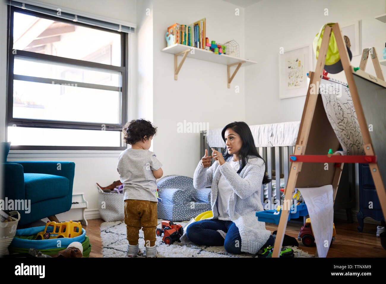 Mother teaching sign language to son at home Stock Photo